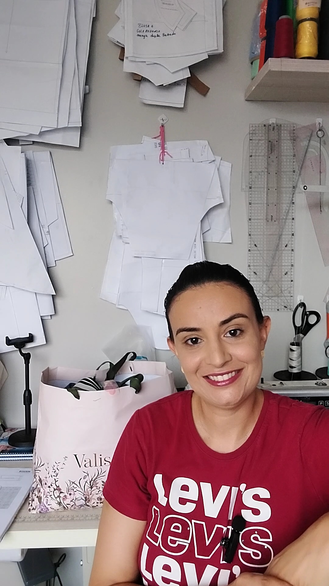 Ateliê de costura organizado com máquina, tecidos e materiais para ajustes de roupas